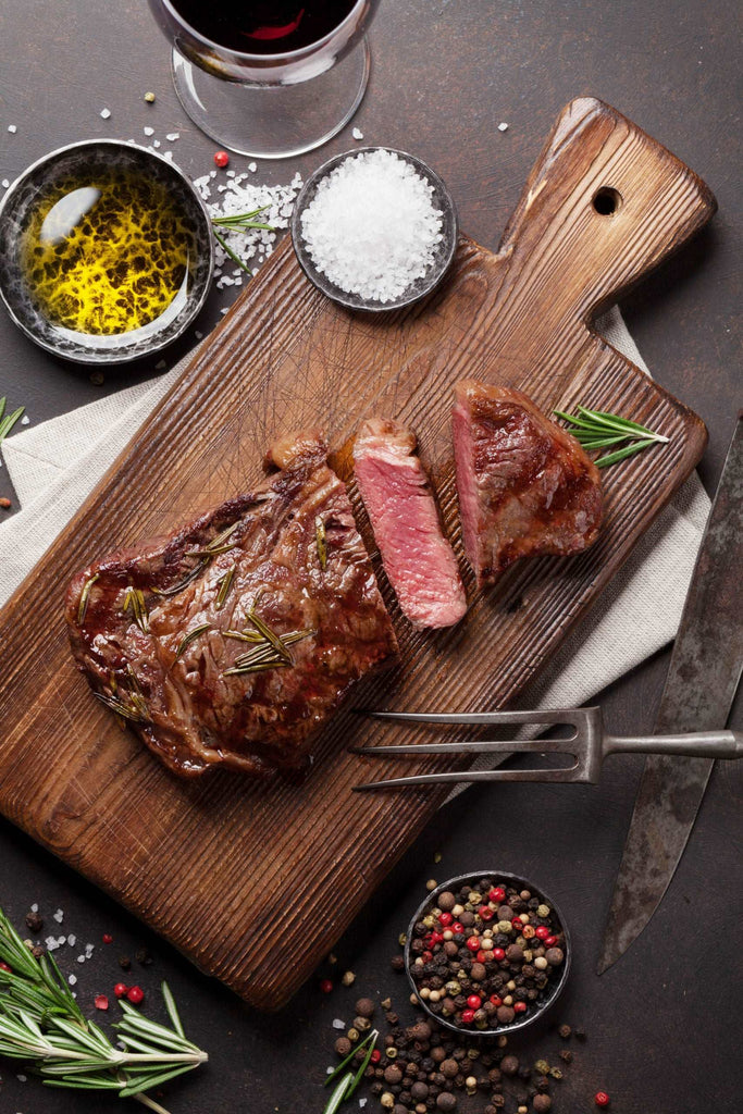 Grilled ribeye beef steak with red wine, herbs and spices