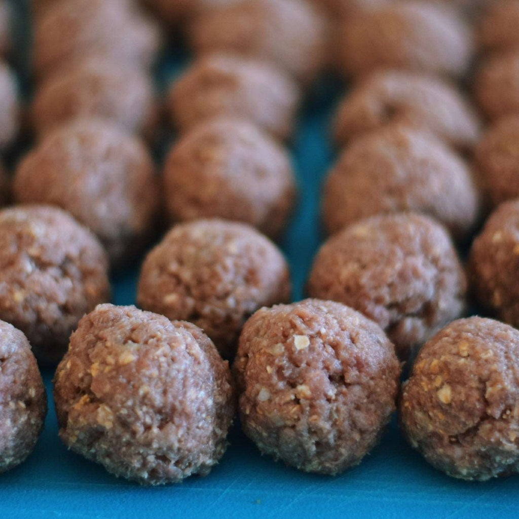 raw-uncooked-beef-meatballs-arranged-on-a-blue-cutting-board_t20_Xxg7yR